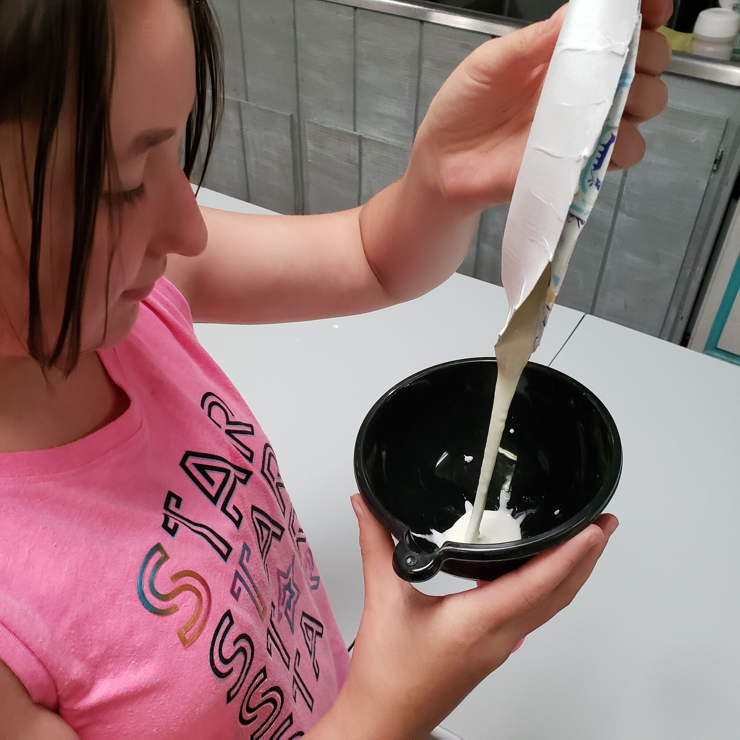 A child mixing batter in a bowl while baking